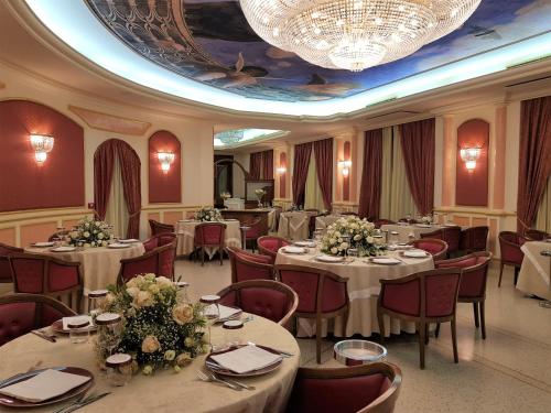 罗切拉伊奥尼卡帕可德普林西皮酒店的一间带桌椅和吊灯的用餐室