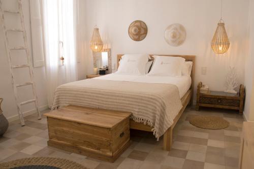 休达德亚Infinito Hotel Boutique - Adults Only的一间卧室配有一张带白色床单和桌子的大床