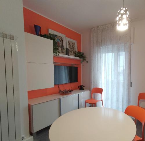 龙基德伊莱焦纳里Tre Continenti - Appartamento con parcheggio privato的一间设有白色桌子和橙色墙壁的用餐室