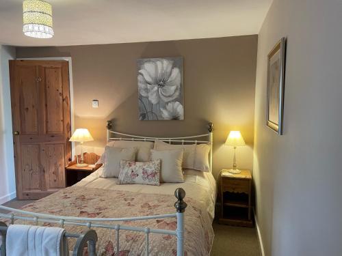 ChideockGingerbread Cottage的一间卧室配有一张床和两个带灯的床头柜