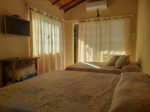 布希奥斯Pousada Alto da Marina的一间卧室设有两张床和窗户。