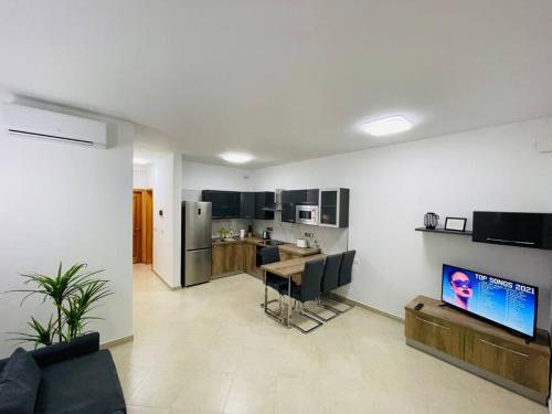艾因西莱姆New, Modern Ground Floor Apartment with Pool的带沙发和桌子的客厅以及厨房。