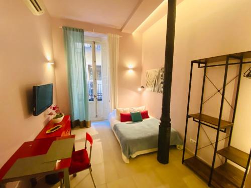 马德里Apartamentos Puzzle Madrid Sol的客房设有带一张床和一张书桌的卧室。