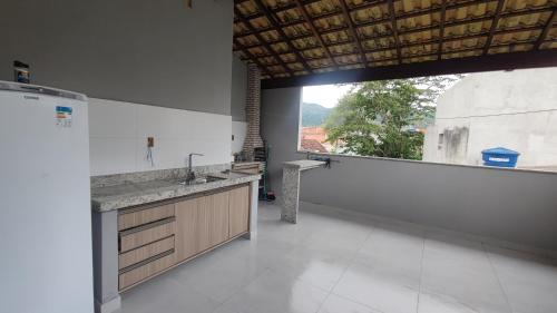 帕拉蒂Casa do Sérgio, Lindo loft-02 moderno e confortável.的一个带水槽和大窗户的厨房