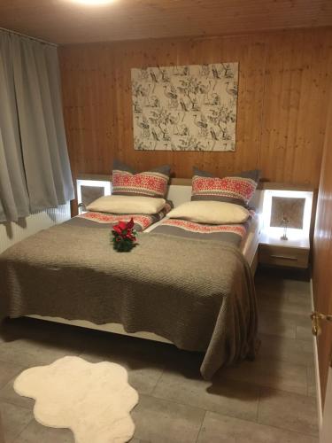 RehdenKranich-Holzferienhaus 'Kleine Auszeit'的一间卧室配有一张带红色枕头的大床