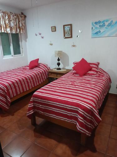 坎昆Mariposas Rooms的配有红色和白色毯子的客房内的两张床