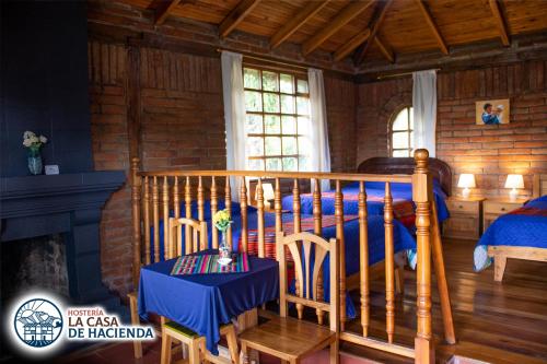 奥塔瓦洛La Casa de Hacienda的卧室配有一张床和一张桌子及椅子