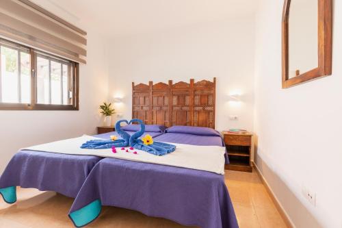 科拉雷侯Casa Garcia的一间卧室配有一张带紫色床单和玩具的床。