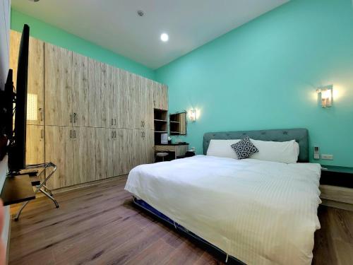 Feng-li翠綠色民宿的卧室配有一张白色大床和蓝色的墙壁
