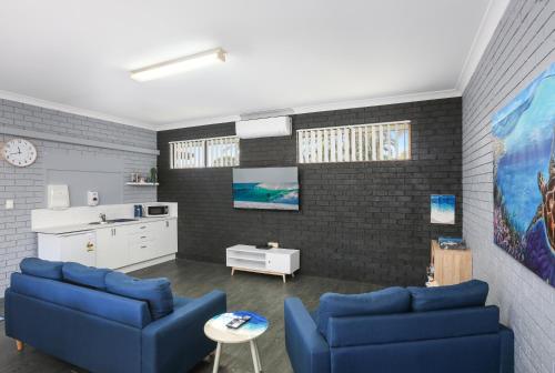 堤维德岬金字塔假日公园的一间带2张蓝色沙发的客厅和一间厨房