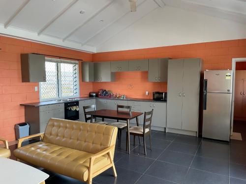 VaiteleKeris Rental Houses的厨房配有沙发、桌子和冰箱。