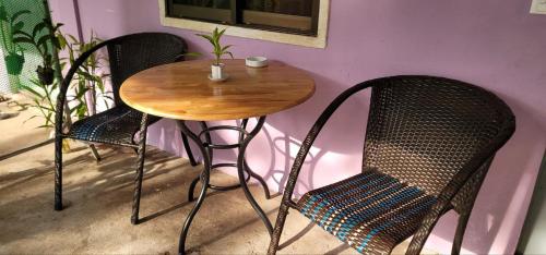 暹粒The Purple House的一张木桌、两把椅子和一张桌子及椅子