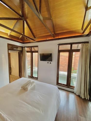 Tjolomaduchrome hotel & resort solo的卧室设有一张带窗户的白色大床