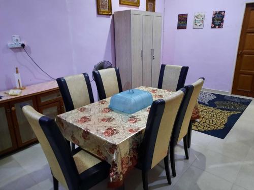 Kampong Tanjong GelamMUAZDIANA HOMESTAY di KUALA NERUS, GONG BADAK的桌子和椅子,上面有一张桌子和一个蓝色的袋子