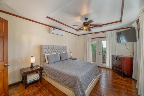 罗阿坦Exclusive Full House - 3 BDRM & 3 BATH - 3min Beach的一间卧室配有一张床和吊扇