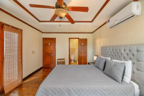 罗阿坦Exclusive Full House - 3 BDRM & 3 BATH - 3min Beach的一间卧室配有一张床和吊扇