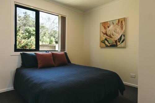 奥福德Rivers Edge Retreat的一间卧室设有蓝色的床和窗户。