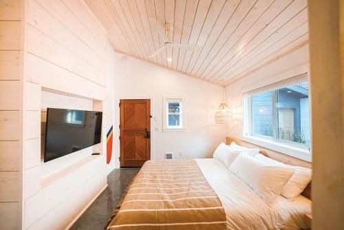 斯廷森海滩Shortboard Room includes Queen Bed的一间卧室配有一张床和一台平面电视