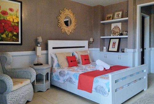 MolaveRedDoorz @ Vine Molave的一间卧室配有一张床、一把椅子和镜子