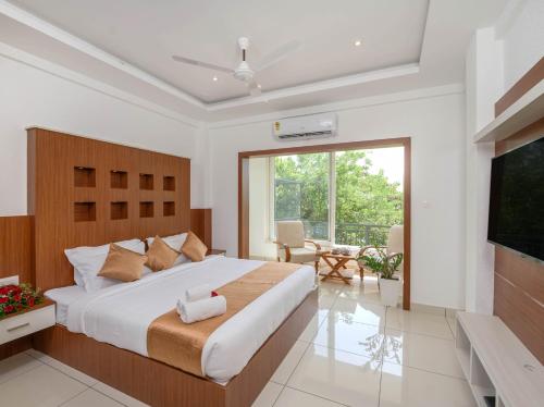 蒙纳Sprise Munnar Resort and Spa的一间卧室设有一张大床和一个大窗户