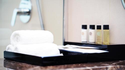 吉达Jasmine Garden Hotel的浴室的柜台配有白色毛巾和镜子