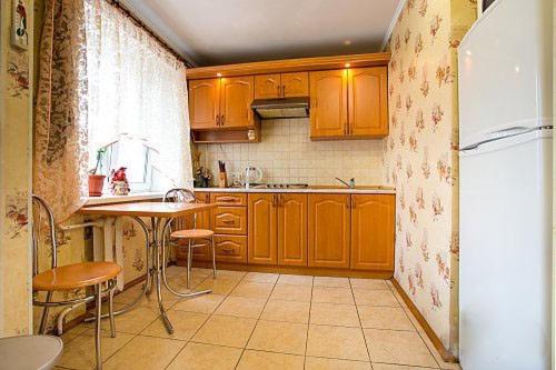 尼古拉耶夫Two-bedroom apartment on Lenina avenue的厨房配有木制橱柜、桌子和冰箱。