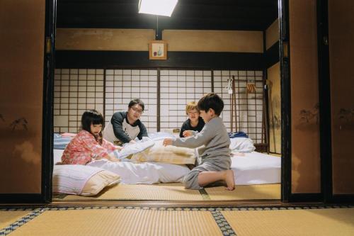 仙北Stay and Discover Nishinoya的一群人坐在房间里的床边