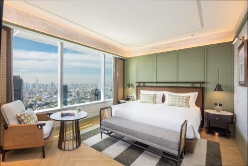 曼谷易思廷大酒店帕亚泰的一间卧室配有一张床、一把椅子和一个大窗户
