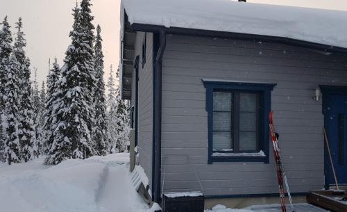 索特Air-conditioned holiday home Vutnusmaja at Iso-Syöte的旁边是雪的房子