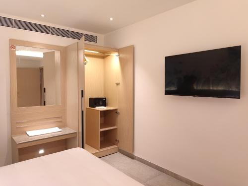 维沙卡帕特南Signature Hotels的卧室配有一张床,墙上配有电视
