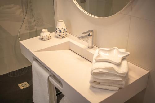 阿亚蒙特Apartamento sobre el rio Guadiana的浴室配有带镜子的盥洗盆和毛巾