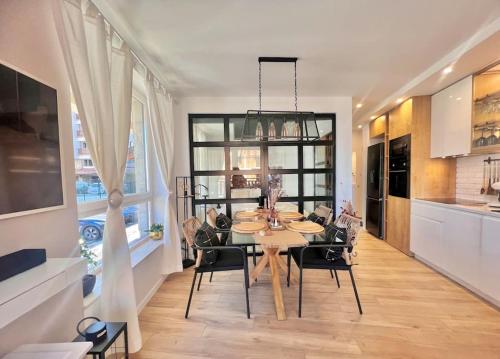 班斯科Boutique lux design apartment @Bansko Royal Towers的厨房以及带桌椅的用餐室。