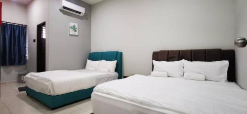 波德申Bahagia 137 Homestay with private pool的酒店客房,配有两张带白色床单的床