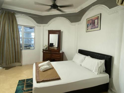 龙运Raihan Beach Resort的一间卧室配有一张带吊扇和镜子的床
