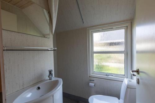 BryrupVelling Koller Hotel og Camping的一间带白色卫生间的浴室和窗户。