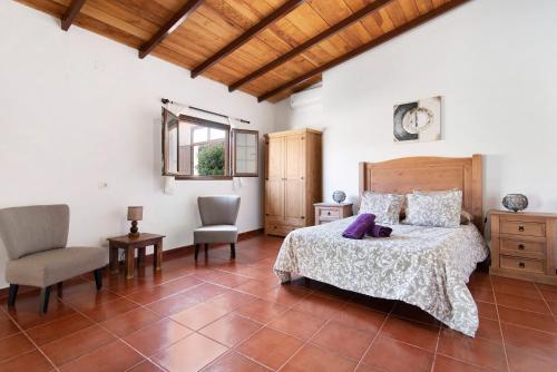 因赫尼奥Casa Las Toscas的一间卧室配有一张床、一把椅子和一张桌子