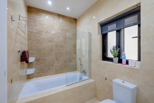 圣朱利安斯Stylish 3 Bedroom Holiday Apartment in St Julians的带淋浴、浴缸和卫生间的浴室
