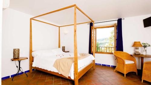 穆斯捷-圣玛丽巴斯蒂德帕拉东酒店的一间卧室设有天蓬床和窗户。