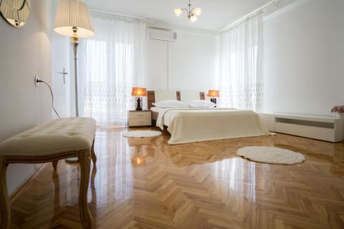 斯普利特Jelena Apartment的一间白色卧室,配有两张床,铺有木地板