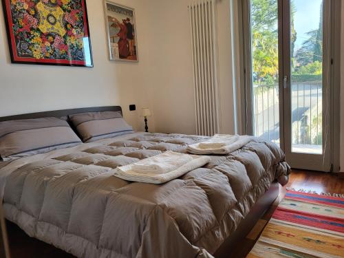 特雷梅佐Residence Belvedere Apartment Volesio的一间卧室配有一张大床和毛巾