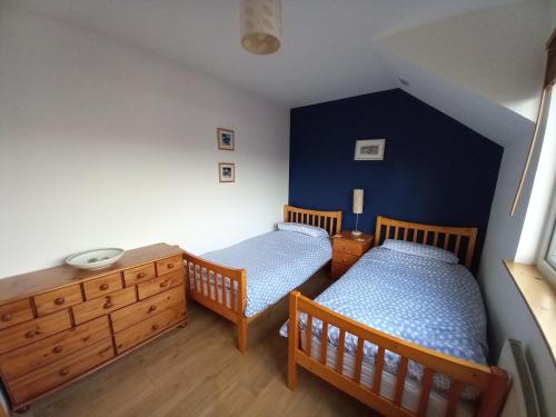 因弗雷里The Curling Pond, Dalmally Road, Inveraray的卧室设有两张单人床和蓝色的墙壁