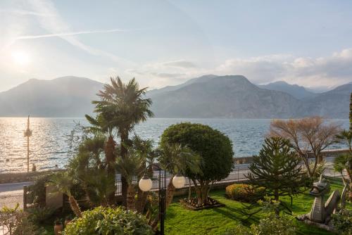 布雷佐内加尔达Hotel Drago - Garda Lake Collection的享有树木和山脉的水域景色