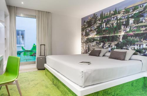 格拉纳达Hotel Maciá Granada Five Senses Rooms & Suites的卧室配有一张白色大床和一张绿色椅子