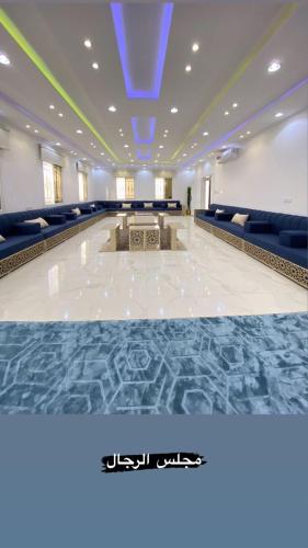 As Sayl aş Şaghīrاستراحة ابن وصيص للمناسبات的一间大房间,配有蓝色的椅子和白色的地板