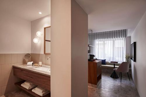 雅典The Social Athens Hotel, a member of Radisson Individuals的一间带水槽的浴室和一张带椅子的桌子