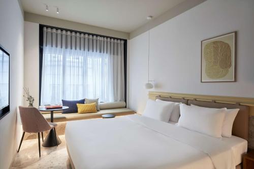 雅典The Social Athens Hotel, a member of Radisson Individuals的卧室设有一张白色大床和一扇窗户。