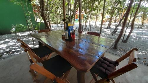 库穆鲁沙蒂巴Chalés Guigó-Cumuruxatiba的一张带椅子和瓶装啤酒的木桌