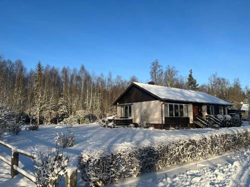 BroakullaFerienhaus in Broakulla mit Sauna的雪地小木屋,带栅栏