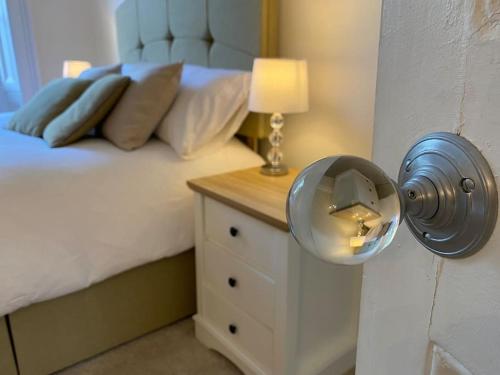 利明顿温泉Regency Apartment的一间卧室配有一张床和一张带台灯的桌子