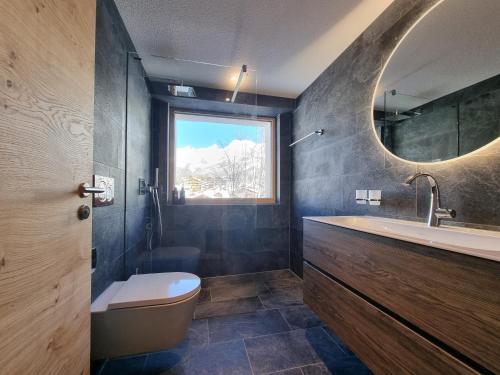 萨斯费Riverside 3rd Floor North的一间带水槽、卫生间和镜子的浴室